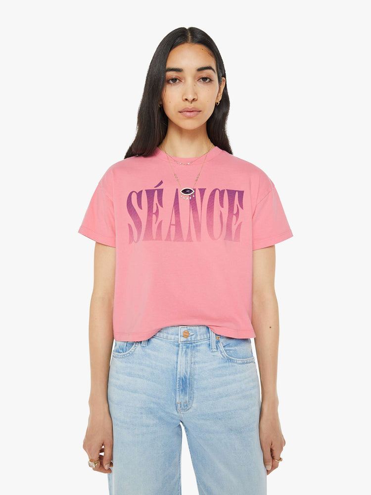 Front view of a pink oversized crewneck tee with drop shoulders, a cropped hem and a boxy fit and purple print.