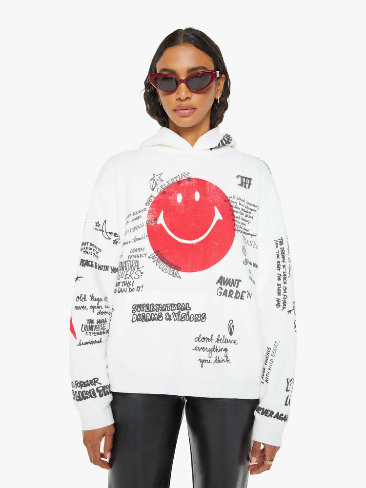 Front view of a woman in a classic hoodie with drop shoulders, a front patch pocket and ribbed hems in white  and red smiley face with drawn scribbles.