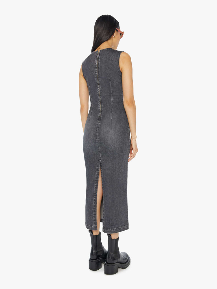 Back view of a woman in a dark grey  sleeveless denim midi dress with a crewneck, seamed details and a narrow fit. 