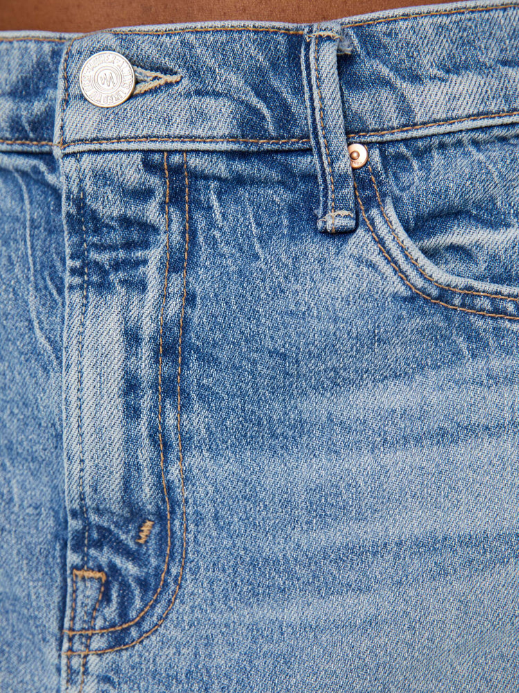 Swatch view of a woman super-short denim mini skirt with exposed pocket liners and a frayed hem in a light blue wash.