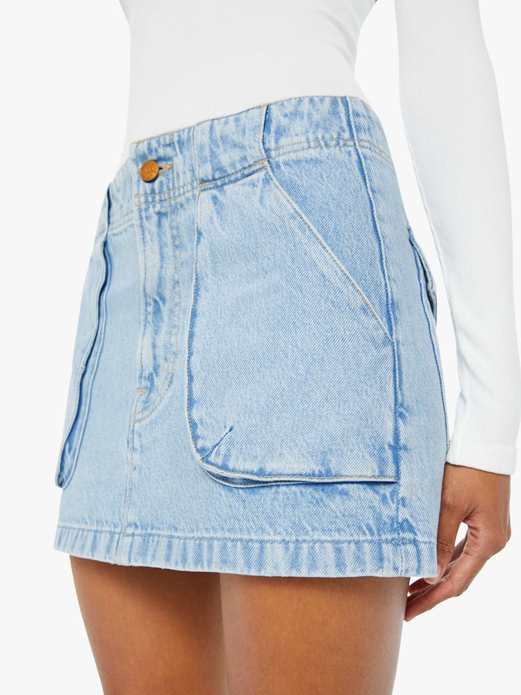 Swatch view of a woman in a light blue denim mini skirt with a zip fly, raised pockets and a clean hem. 