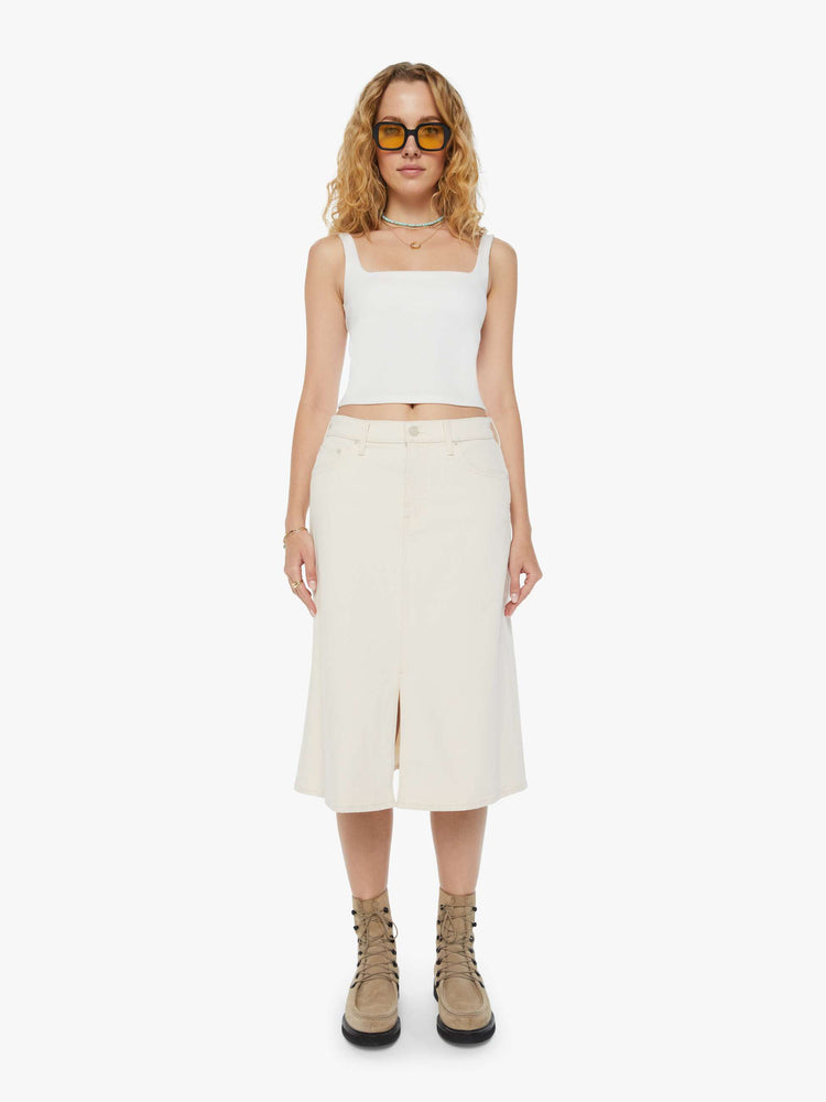 Front view of a woman in a creamy white low-rise skirt with a slouchy A-line fit and a front slit. 