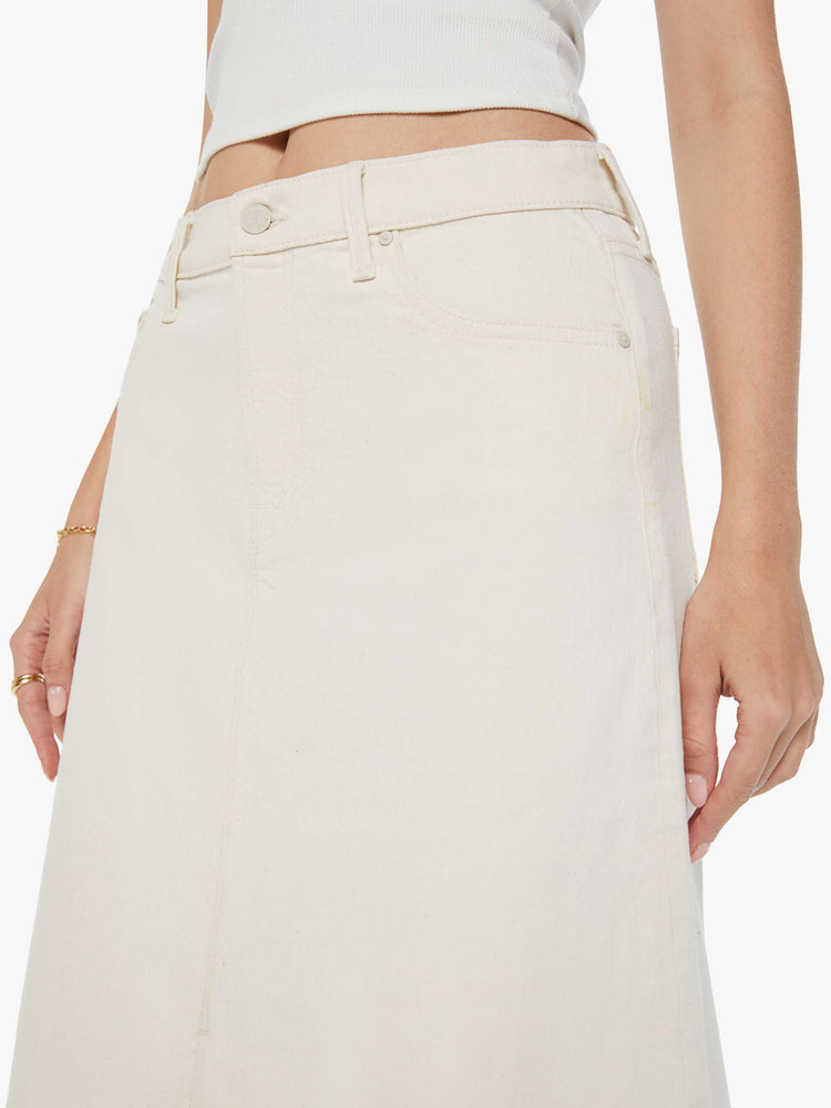 Swatch view of a woman in a creamy white low-rise skirt with a slouchy A-line fit and a front slit. 