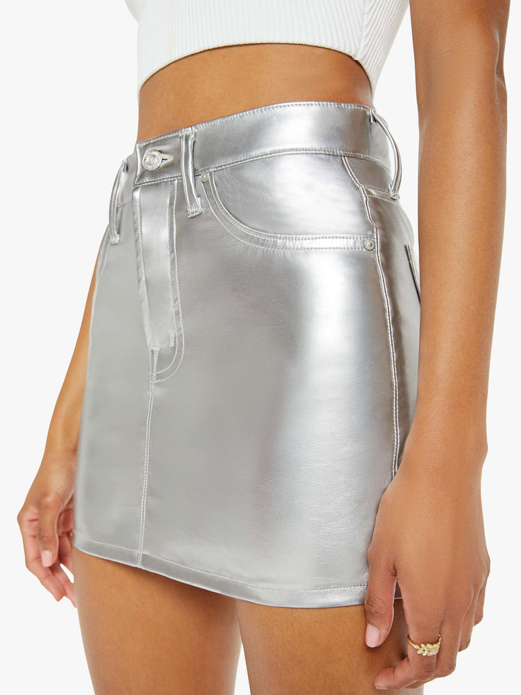 Close up view of a woman in a light silver mini skirt designed to be worn lower on the hips with a zip fly, slim fit and thigh-grazing hem.