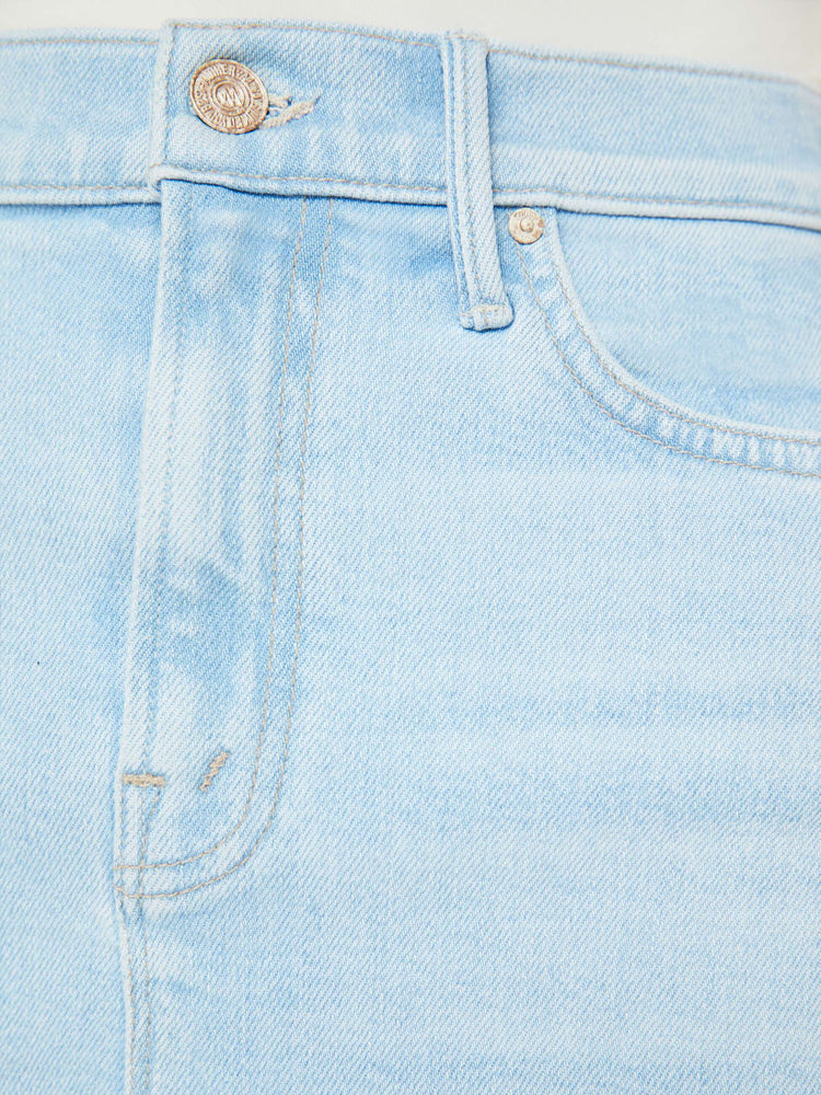 Swatch view of woman in a high-waisted denim midi skirt with an A-line fit and a calf-length hem in a light blue wash.