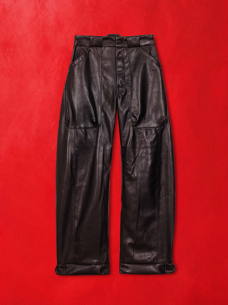 A flat image of a pair of black leather pants against a red background.