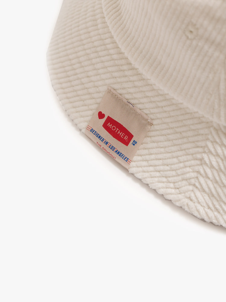 Flat close up an off-white corduroy bucket hat with a rainbow graphic embroidered on the front.