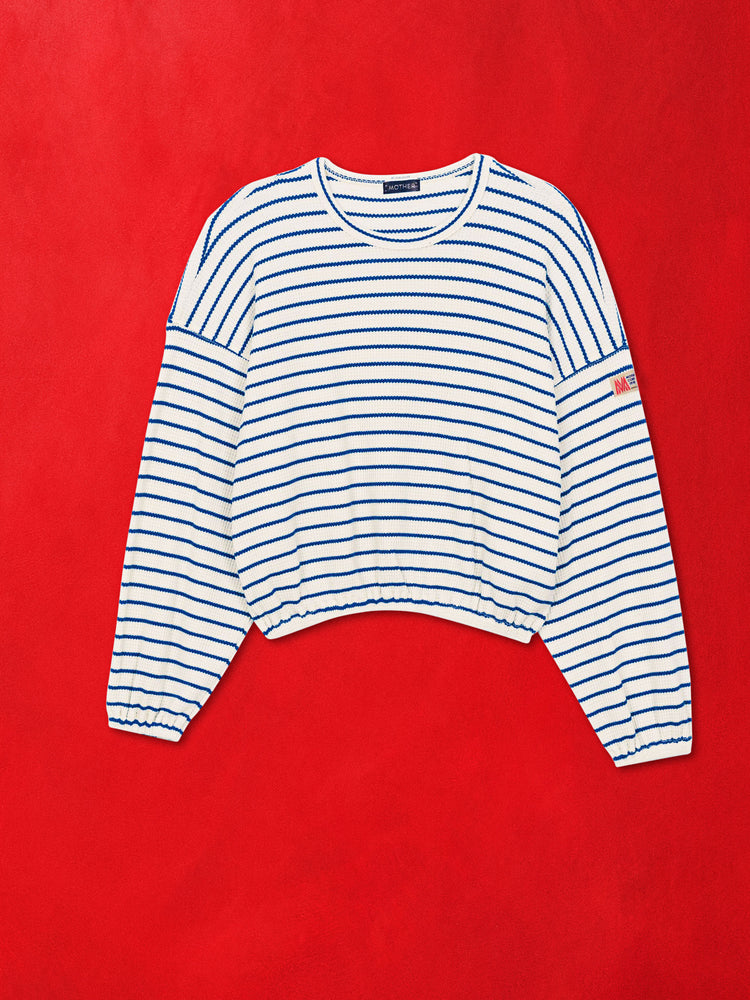 A flat product image of a blue and white striped long sleeve top against a red background.