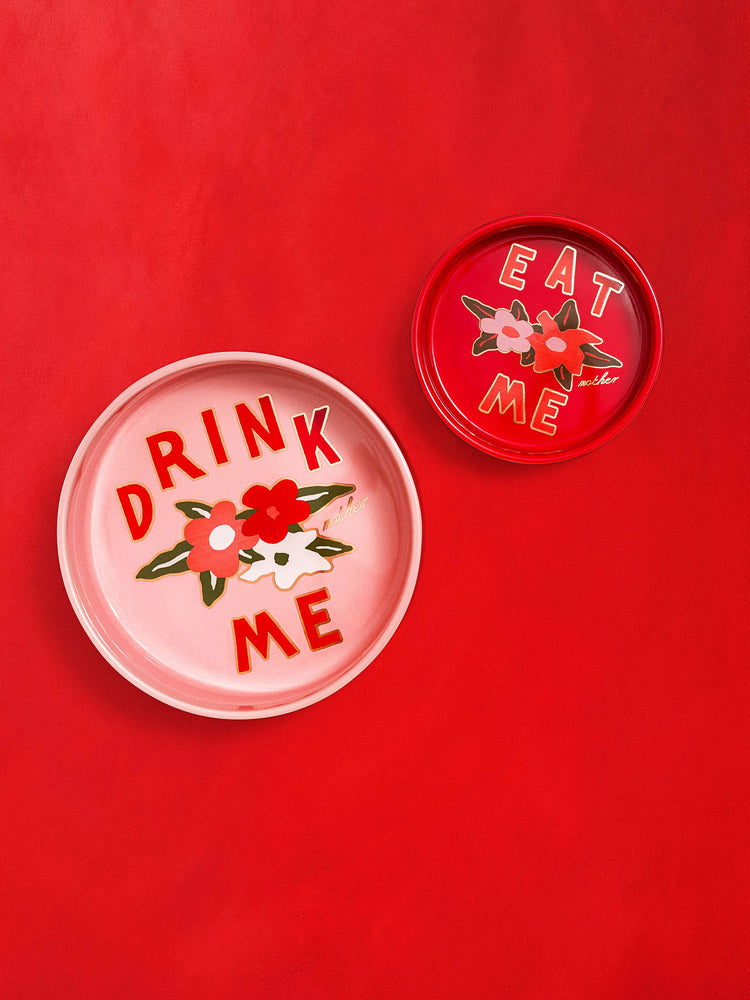 Front view of a set of pet bowls in pink and red, featuring floral graphics, against a red background.