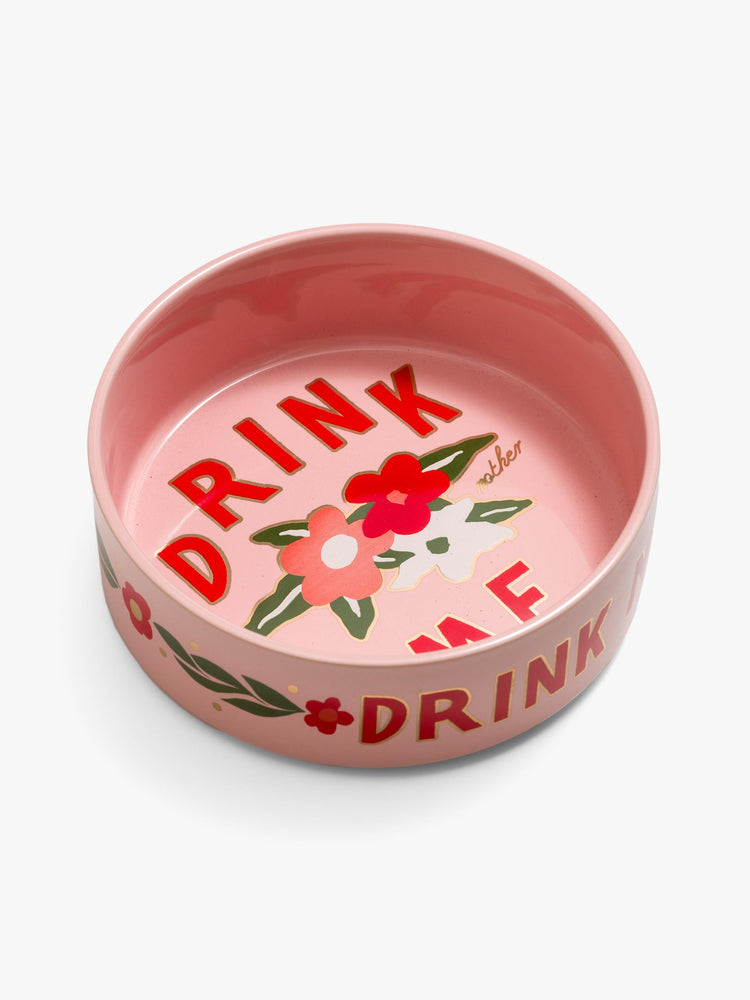 Side angle view of a pink ceramic dog bowls with a little encouragement from MOTHER. 