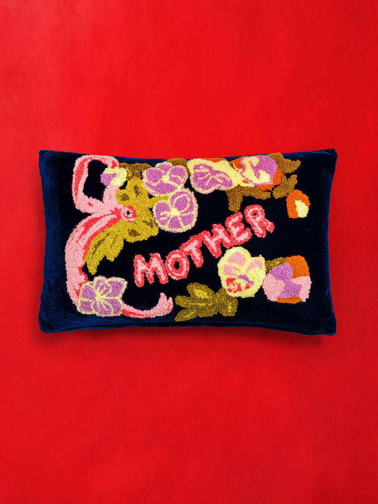 Front view of a dark navy, rectangular pillow featuring embroidered flowers and MOTHER.