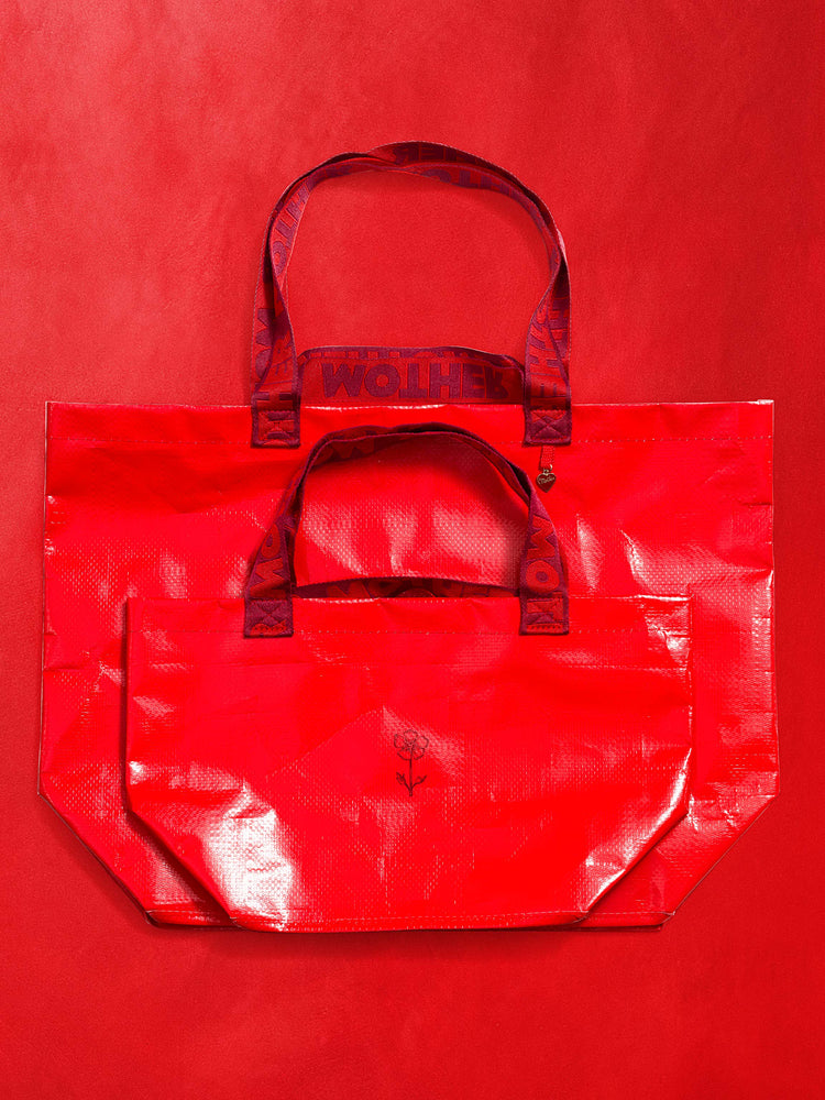 Top view of a set of bright red vinyl bags against a red background.