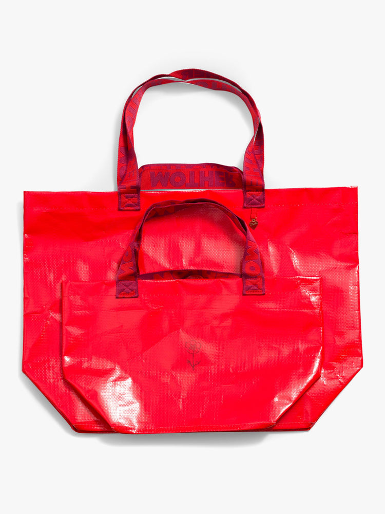 Flat view of a set of two, the red bags feature a boxy, oversized shape, roomy interior, internal pocket, charm, thick branded straps and a pink dust bag.