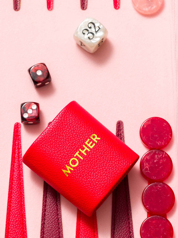 Close up view of pieces from a view of a custom backgammon set is designed in pink, red and maroon.