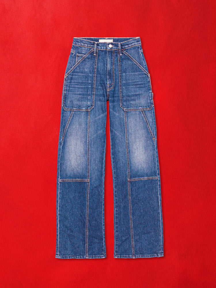 A flat product image of a pair a blue denim jeans with cargo pocket details against a red background.