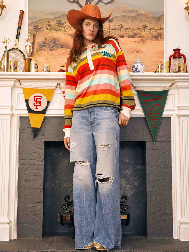 Editorial shot of the woman in a mid blue wide-leg jeans feature a button fly, low-set back pockets, mid rise with a slightly dropped crotch and a 32-inch inseam. 