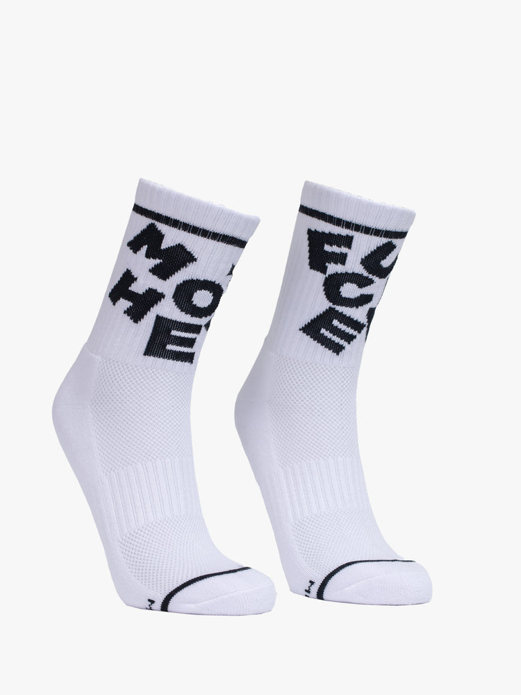 View of white classic tube socks with a bold message in black from MOTHER. 