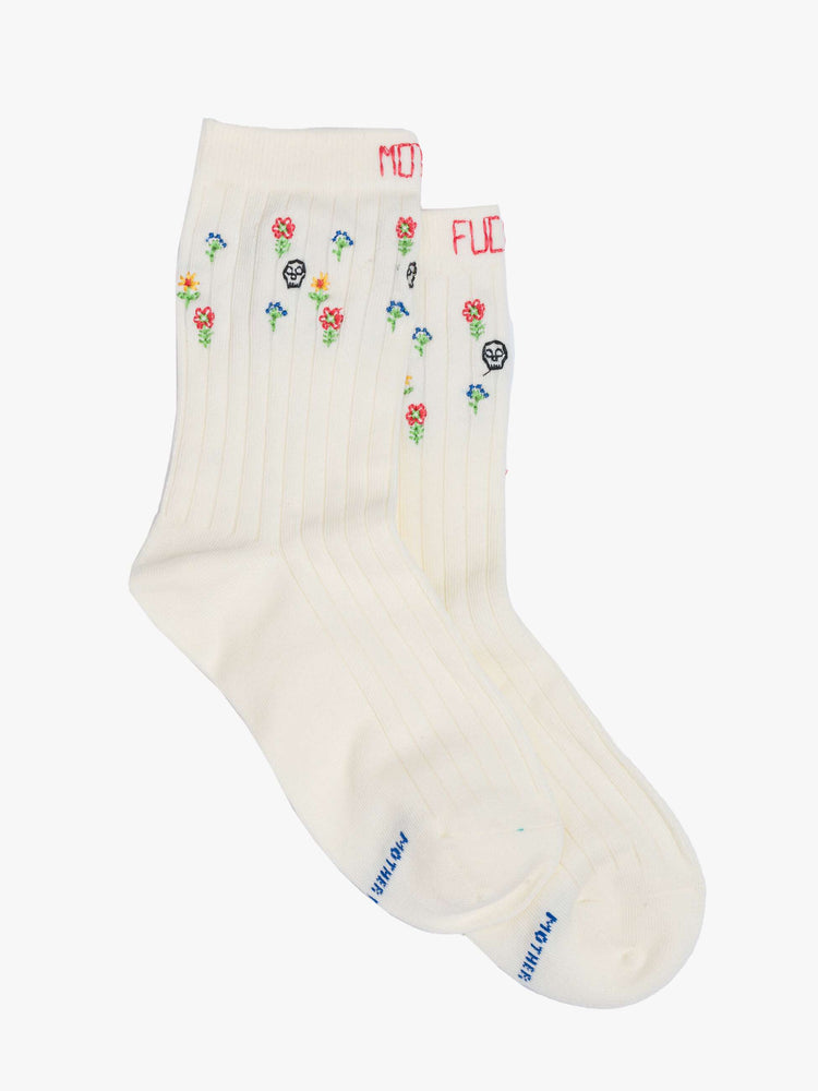 View of classic tube socks in pale yellow with embroidered skulls and flowers.