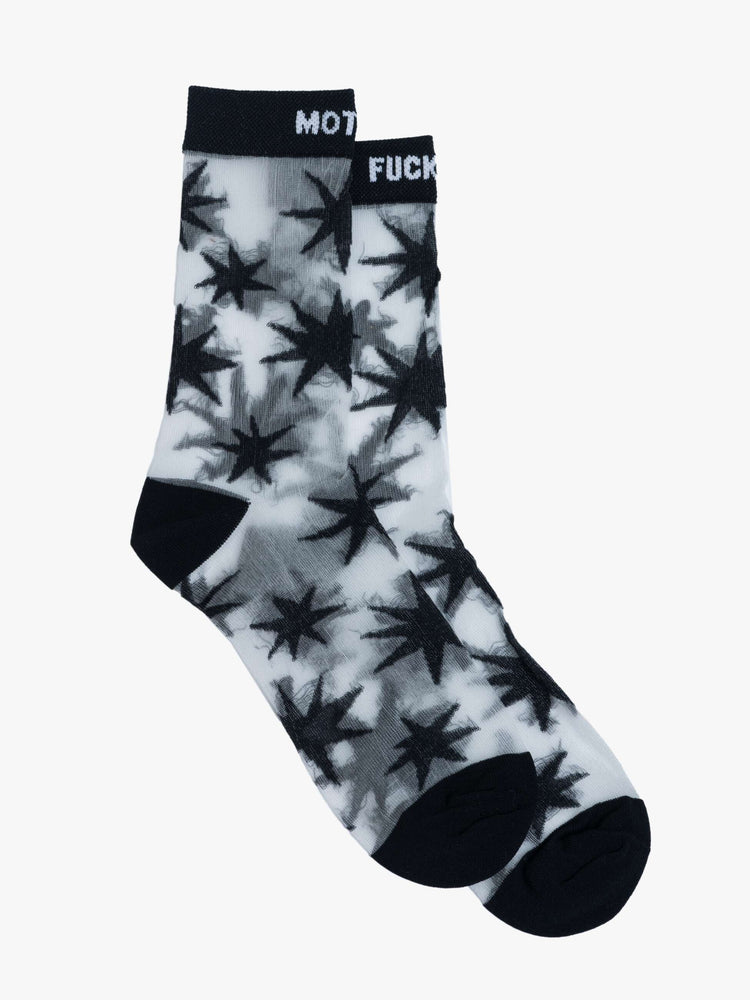 Flat view of  translucent grey fabric with black stars, black trim and text in white socks.