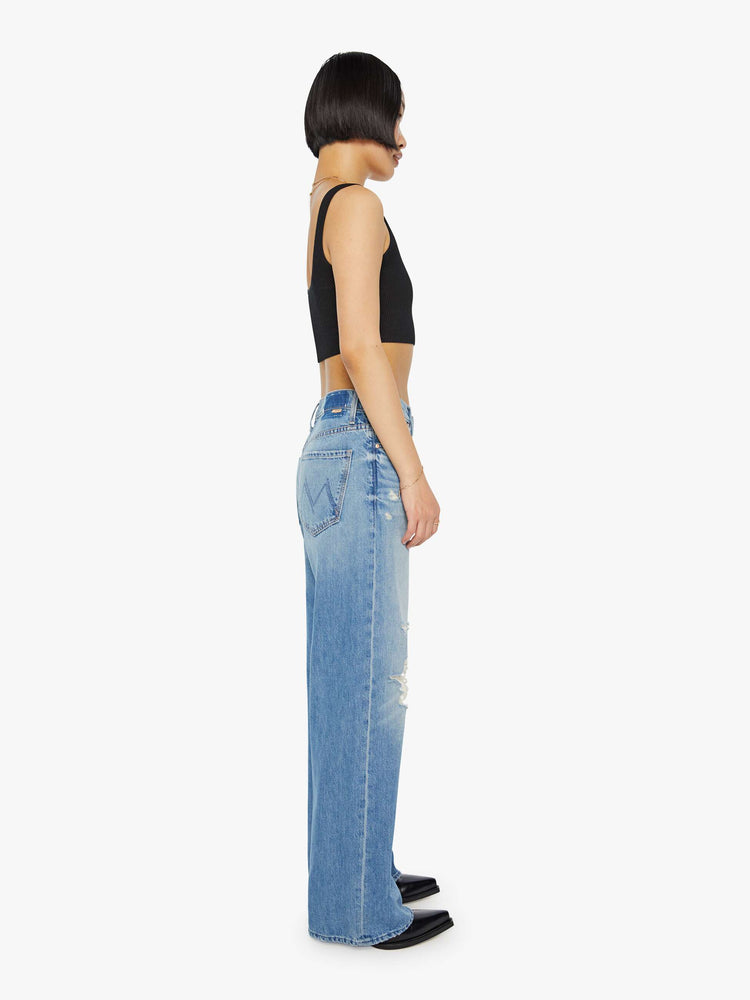 Side  view of a petite light blue washed designed to sit lower on hips with a loose straight leg.