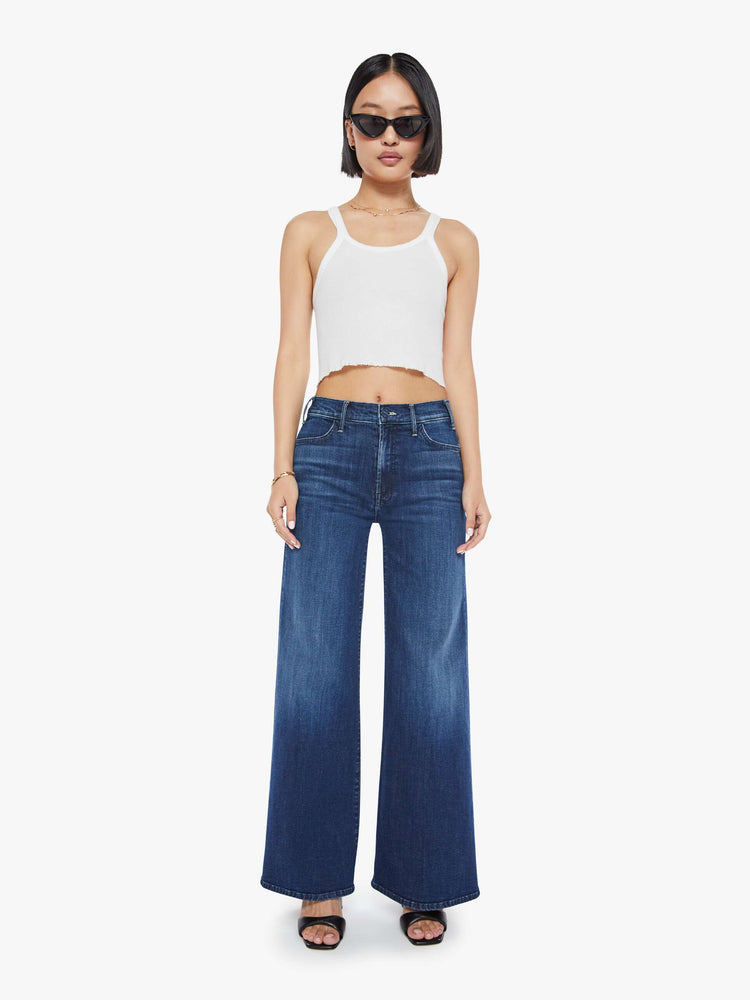 Front view of a petite woman in a dark blue wide leg jeans  with a high rise, 30-inch inseam and a clean hem.