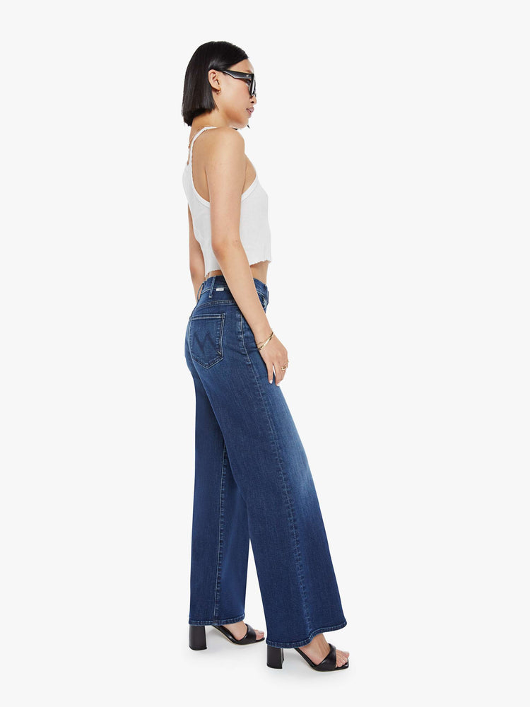 Side view of a petite woman in a dark blue wide leg jeans  with a high rise, 30-inch inseam and a clean hem.