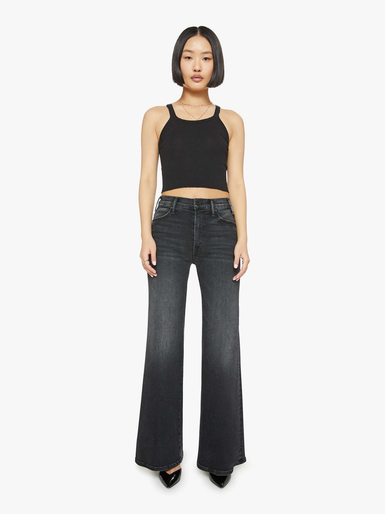 Front view of a petite woman in a black wash  wide leg jeans with a high rise, 30-inch inseam and a clean hem. 