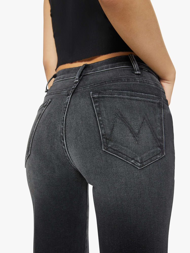 Back close up view of a petite woman in a black wash  wide leg jeans with a high rise, 30-inch inseam and a clean hem. 