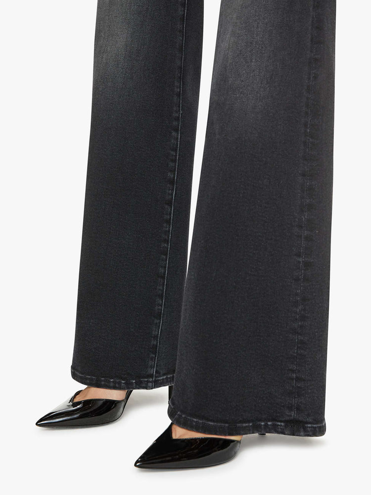 Hem close up view of a petite woman in a black wash  wide leg jeans with a high rise, 30-inch inseam and a clean hem. 