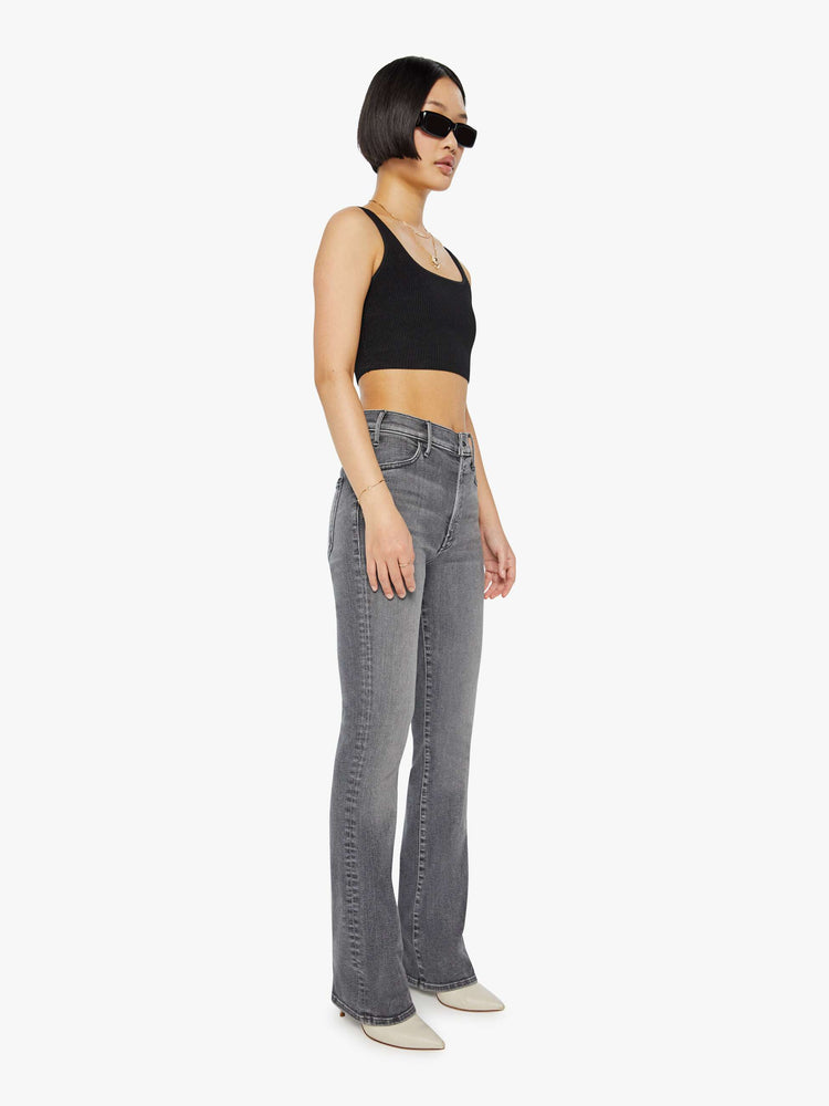 Front view of a woman in a grey High-waisted flare jeans with a longer inseam and a clean hem.