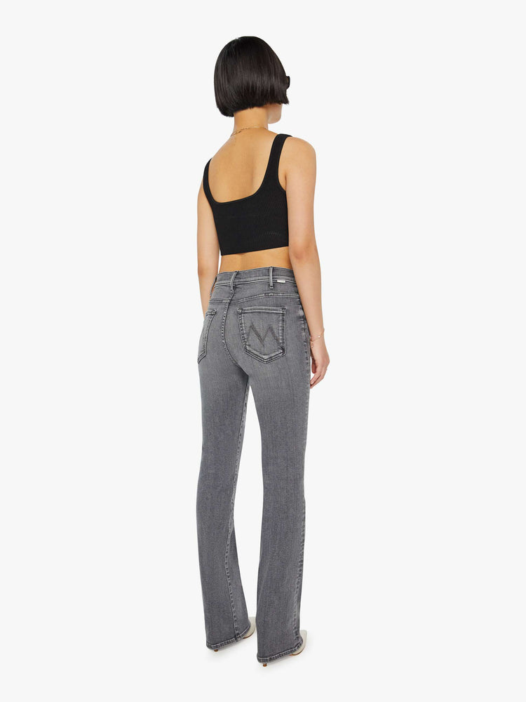 Back view of a woman in a grey High-waisted flare jeans with a longer inseam and a clean hem.