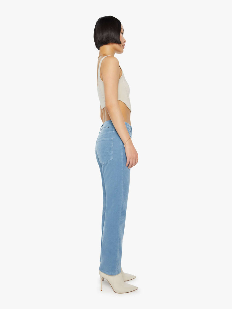 Side view of a woman in a light blue corduroy slim straight-leg features a mid rise, button fly, low-set back pockets and a clean hem. 