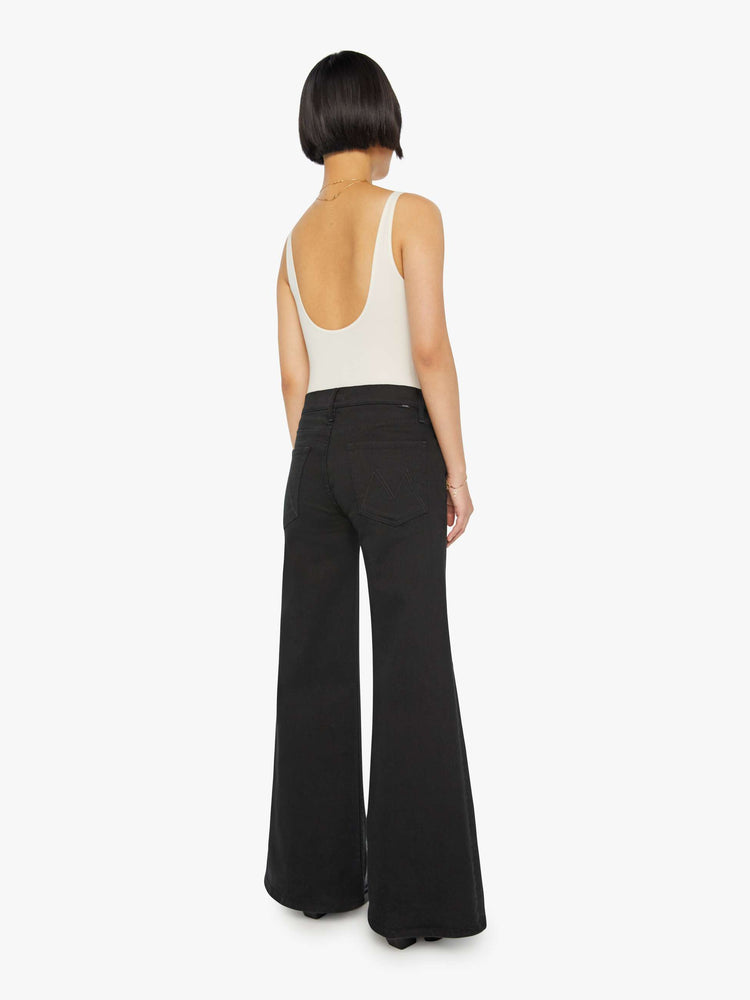 Back view of a woman in a black wide-leg jean with a high rise and a clean, 30-inch inseam.