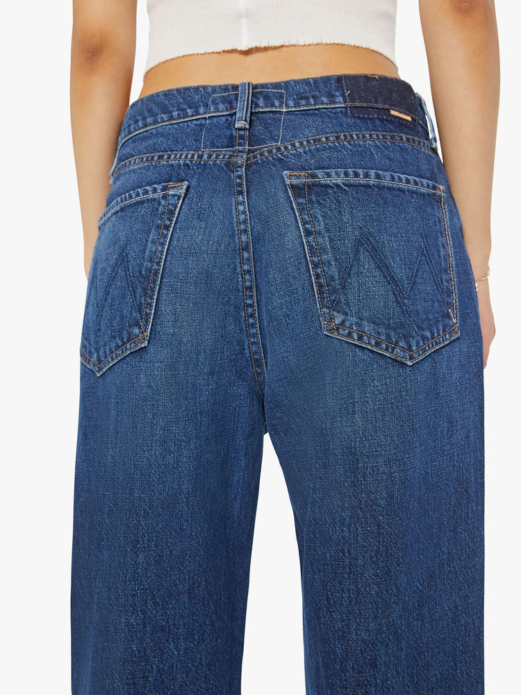 Detailed view of a woman in dark blue straight-leg jeans have a 28-inch inseam and a cuffed hem.