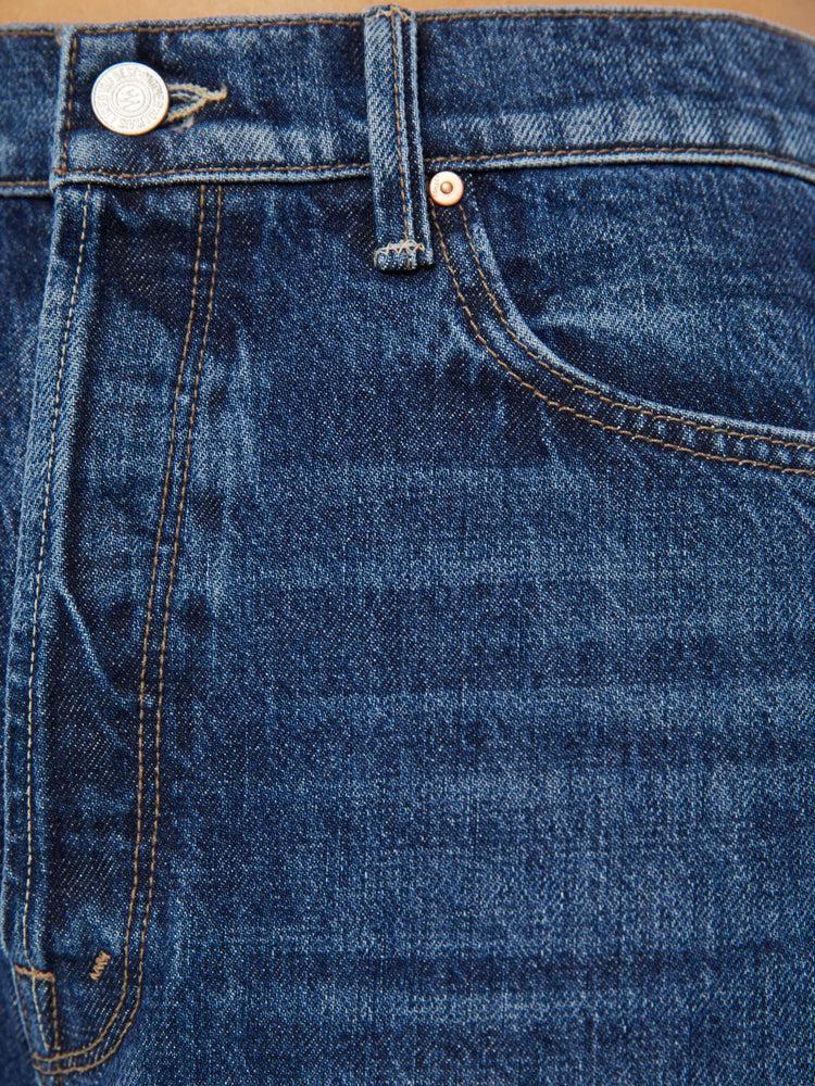 Swatch view of a woman in dark blue straight-leg jeans have a 28-inch inseam and a cuffed hem.