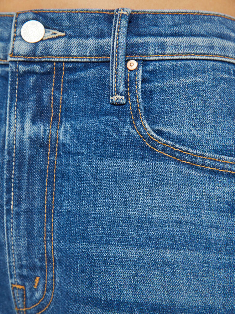 Swatch view of a petites woman in a super high-waisted pants with a full barrel leg, a 26.25-inch inseam and a clean hem in a med blue.