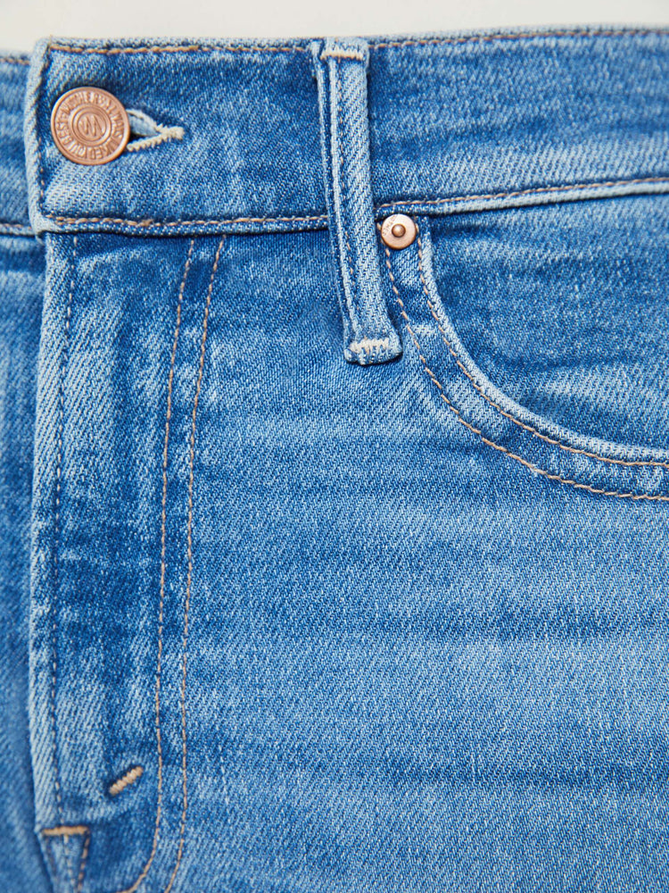 Swatch view of a petites woman high-waisted bootcut is cropped at the ankle with a frayed step-hem in a med blue wash.