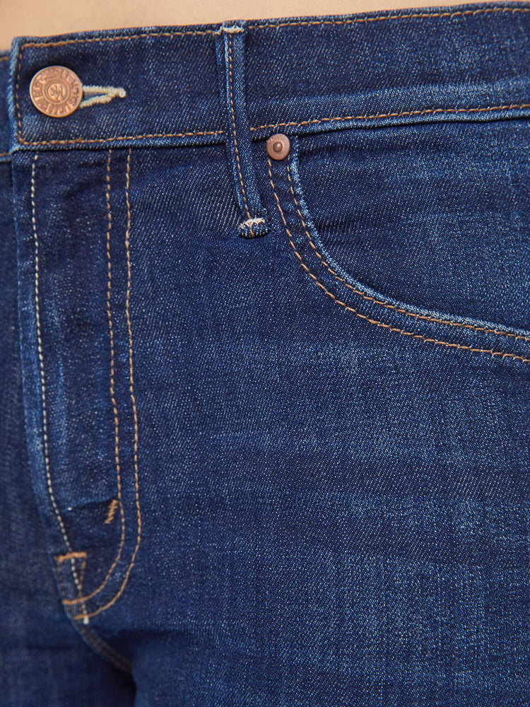 Swatch view of a petite woman in a dark blue wash high-waisted bootcut is cropped at the ankle with a frayed step-hem jean.