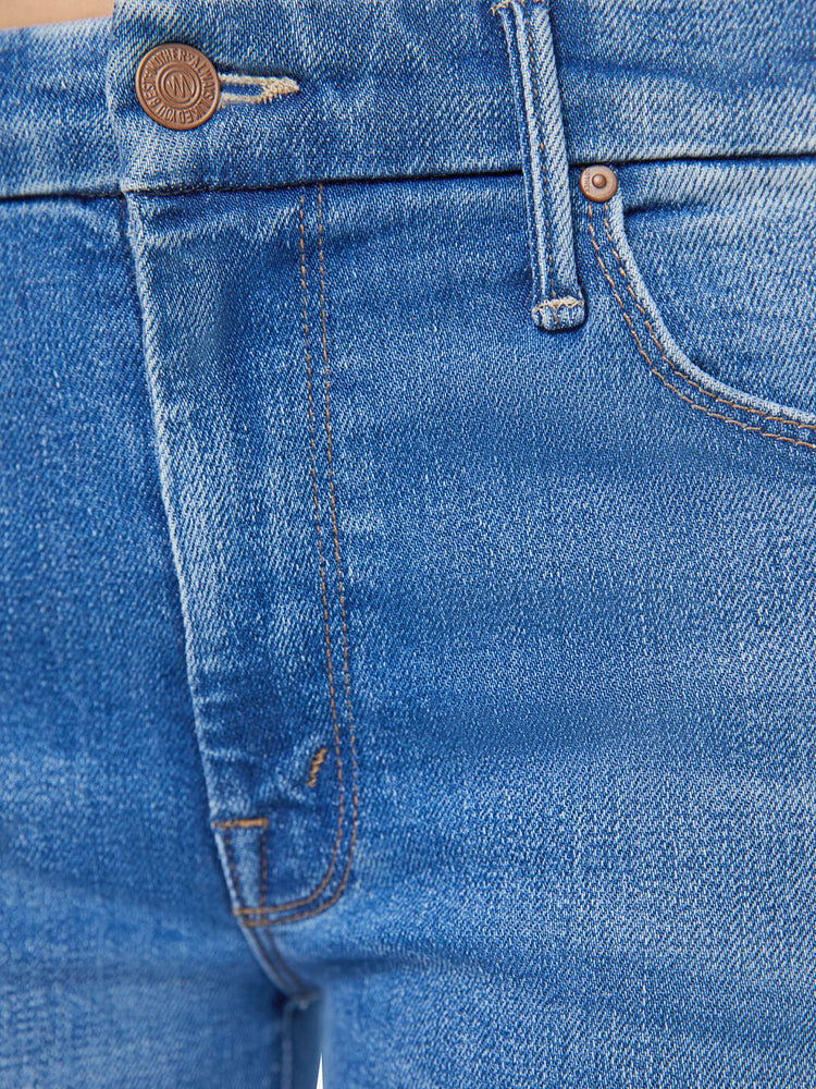 Swatch view of a petite woman in a high-waisted wide leg has a 31-inch inseam and a frayed hem mid blue jean.