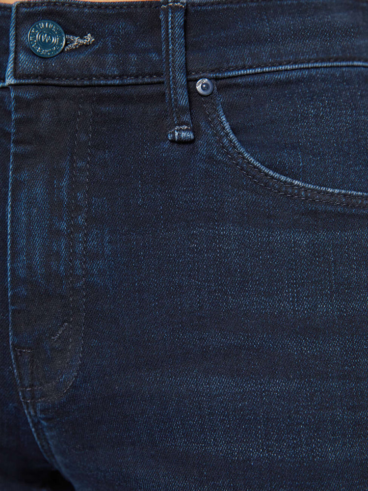 Swatch view of a dark blue mid-rise flare has a 29-inch inseam with a frayed hem.