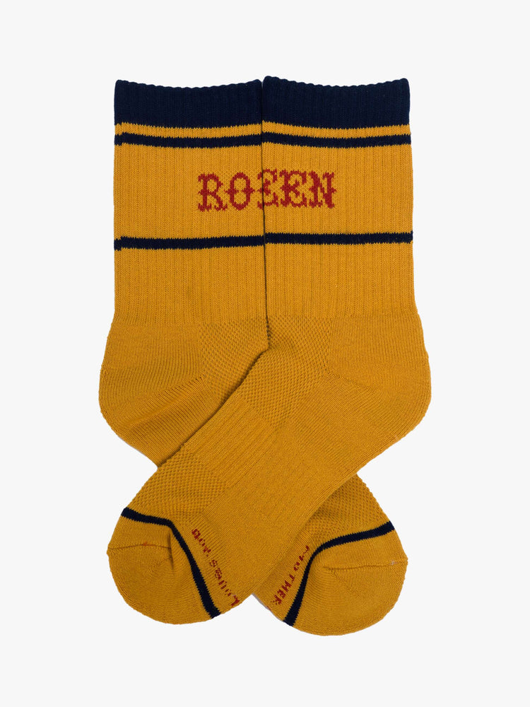 Side flat view of a yellow socks with red lettering that reads "Rodeo Queen" and navy details.