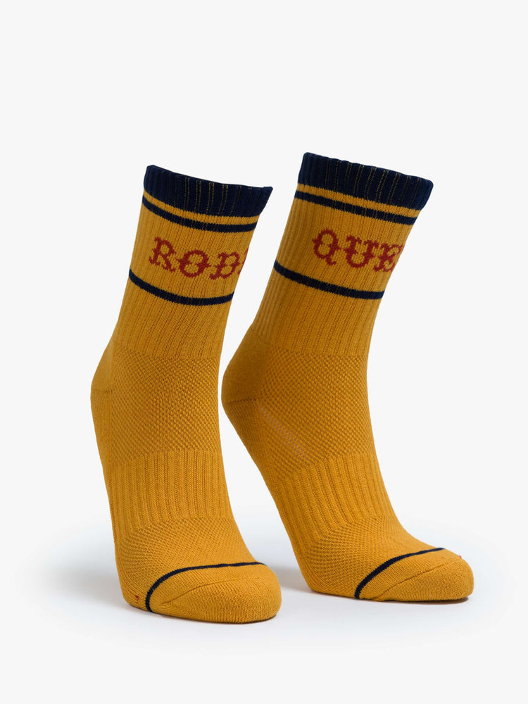 Front view of a yellow socks with red lettering that reads "Rodeo Queen" and navy details.