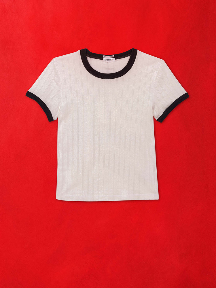 A flat image of a white ringer tee with navy blue trim, against a red background.