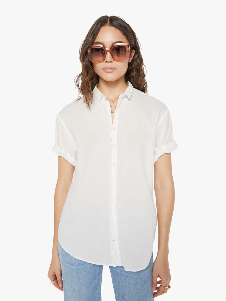 Front view of a woman wearing a white short sleeve button up shirt.