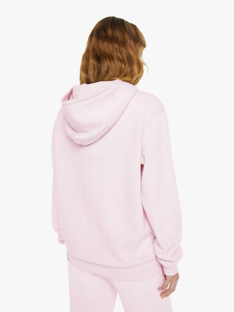 Back view of a woman in a pink with white heart sweatshirt with a front patch pocket and a loose, comfortable fit.