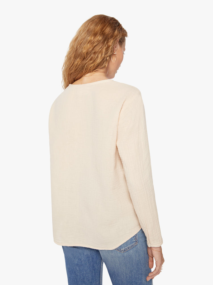 Back view of a woman buttoned vneck, eyelet details shirt in a oat hue.