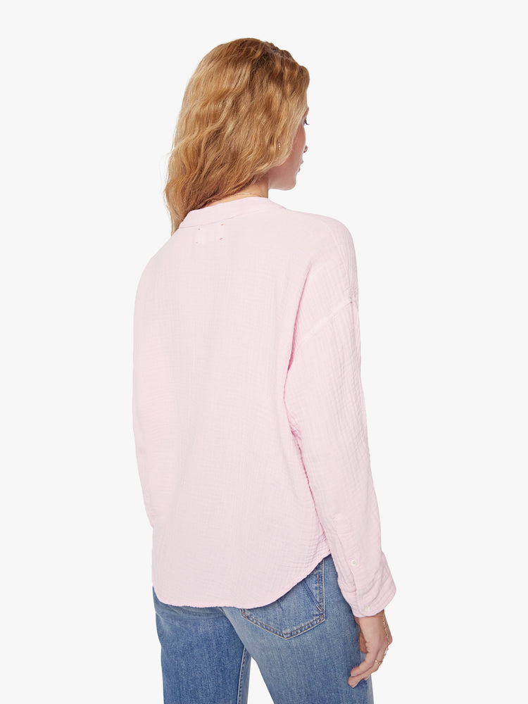 Back view of a woman baby pink blouse with a V-neck with buttons down the front, a curved hem and an airy fit.