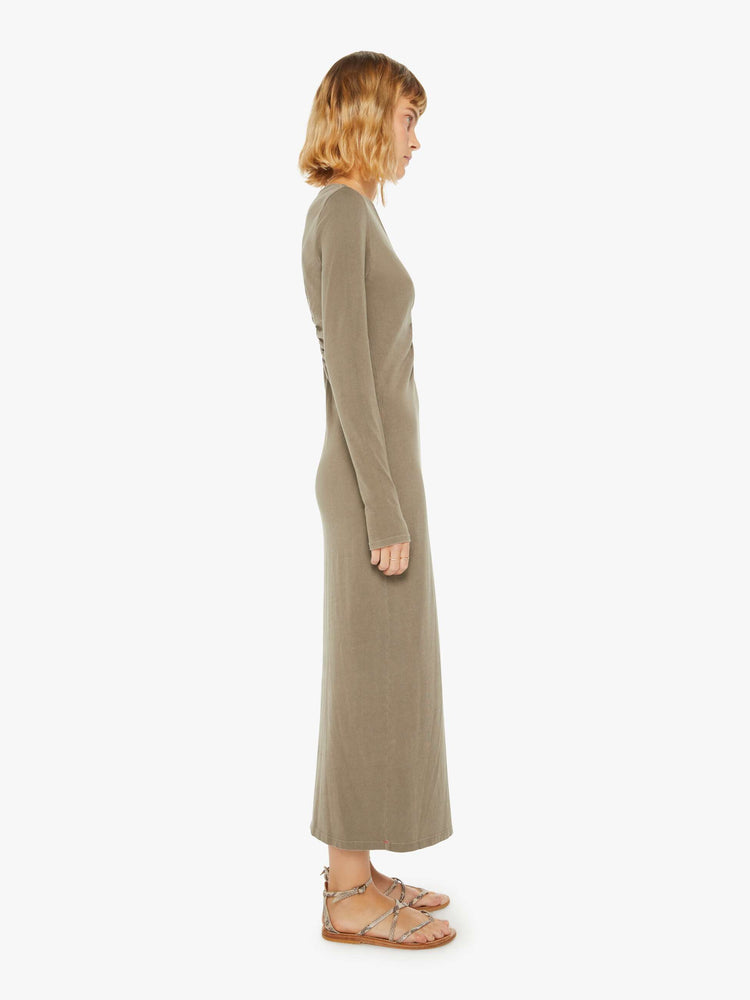 Side view of a woman dusty oluve hue long sleeve dress with a V-neck, gathered seam down the front and a slim fit.