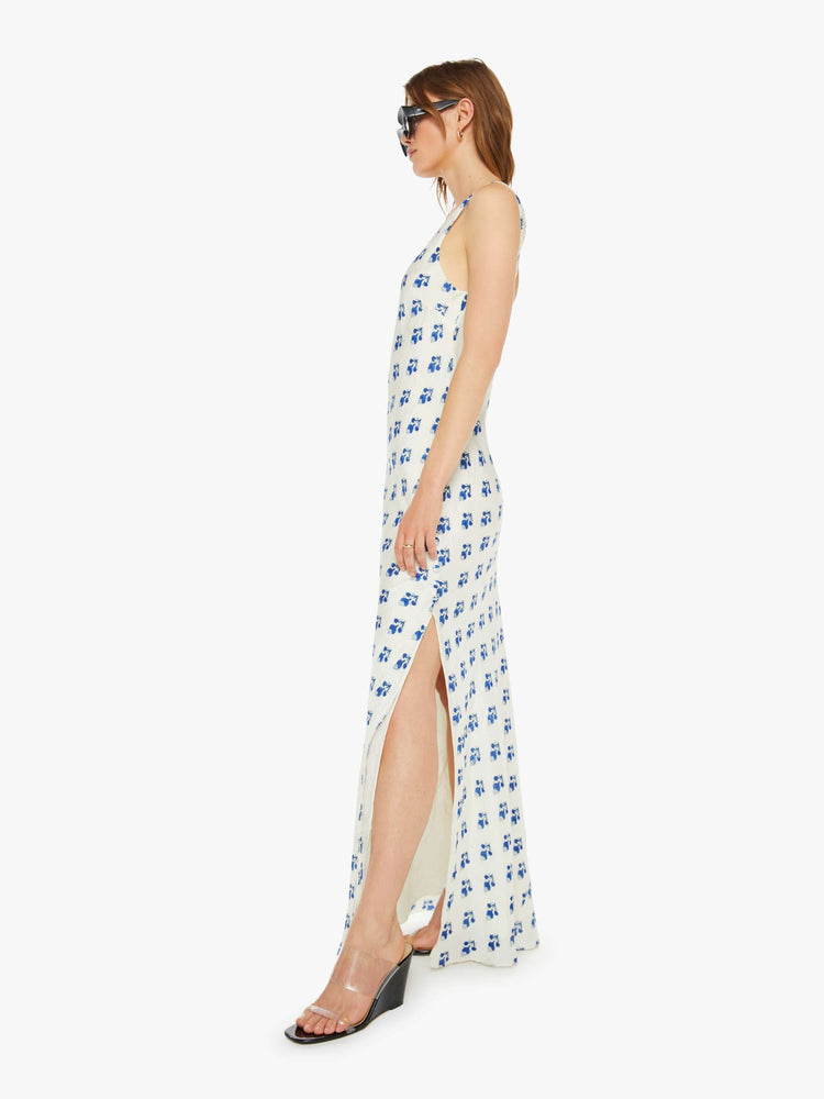 Side view of a woman slip dress in white with a blue porcelain-inspired print, and features a scoop neck, narrow fit and an ankle-length hem.