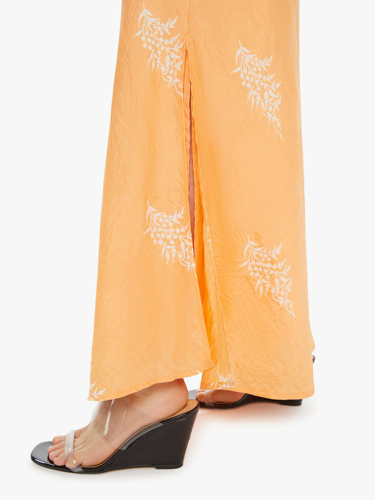 Swatch view of a silk skirt in a peachy-orange with a light pink floral print, and features a slightly narrow A-line fit.